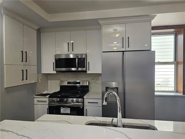 a kitchen with stainless steel appliances granite countertop a stove a sink and a refrigerator