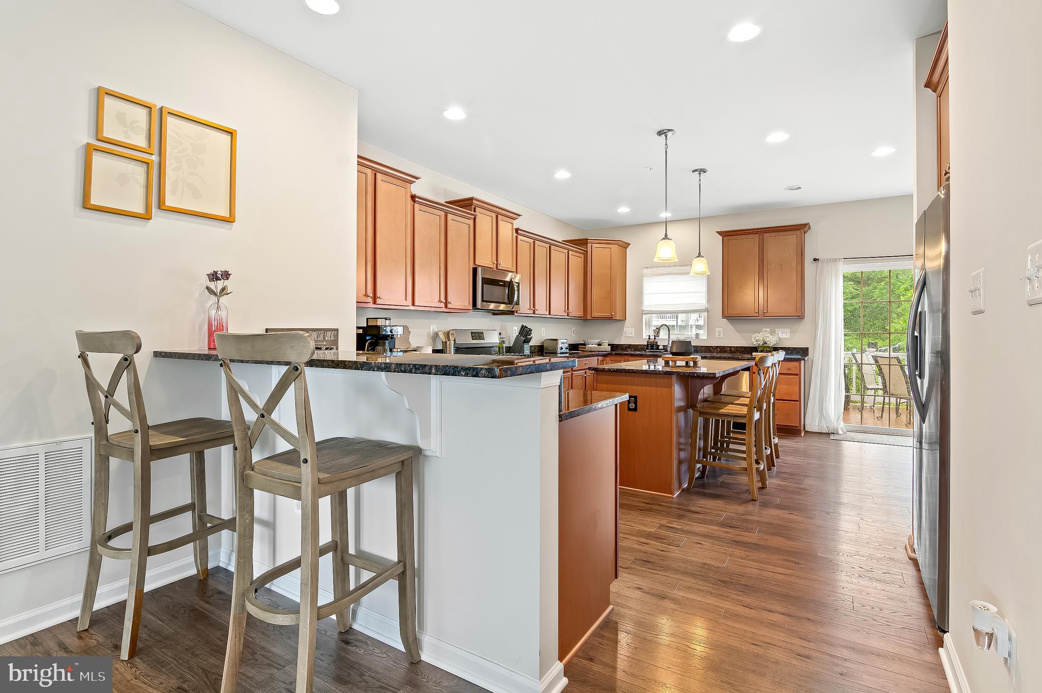 1022 Linden Drive Hanover, MD 21076 - Photo 13 of 42 a kitchen with stainless steel appliances kitchen island granite countertop a table chairs and a refrigerator