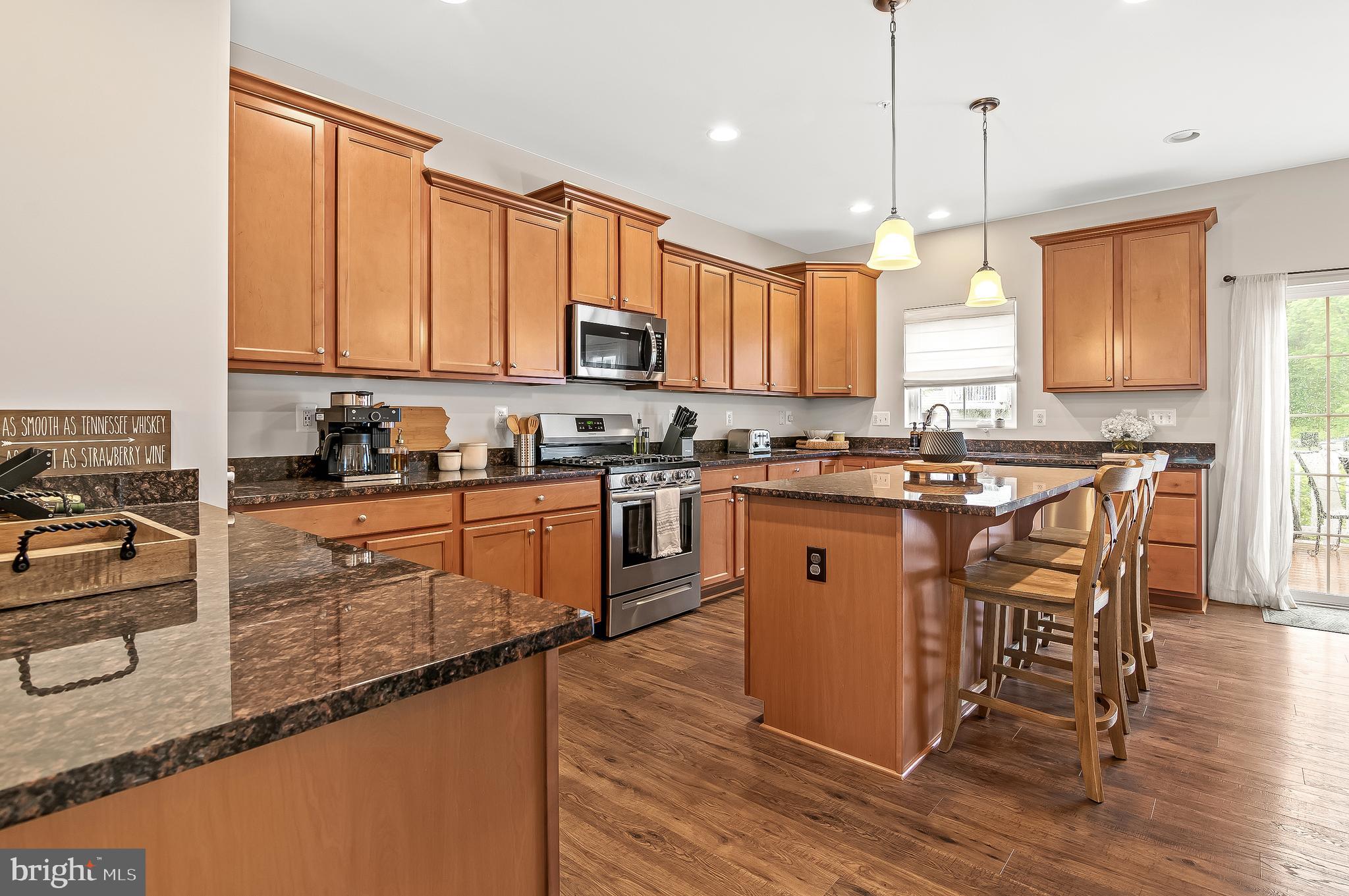 1022 Linden Drive Hanover, MD 21076 - Photo 15 of 42 a kitchen with stainless steel appliances granite countertop wooden cabinets a sink a stove a dining table and chairs