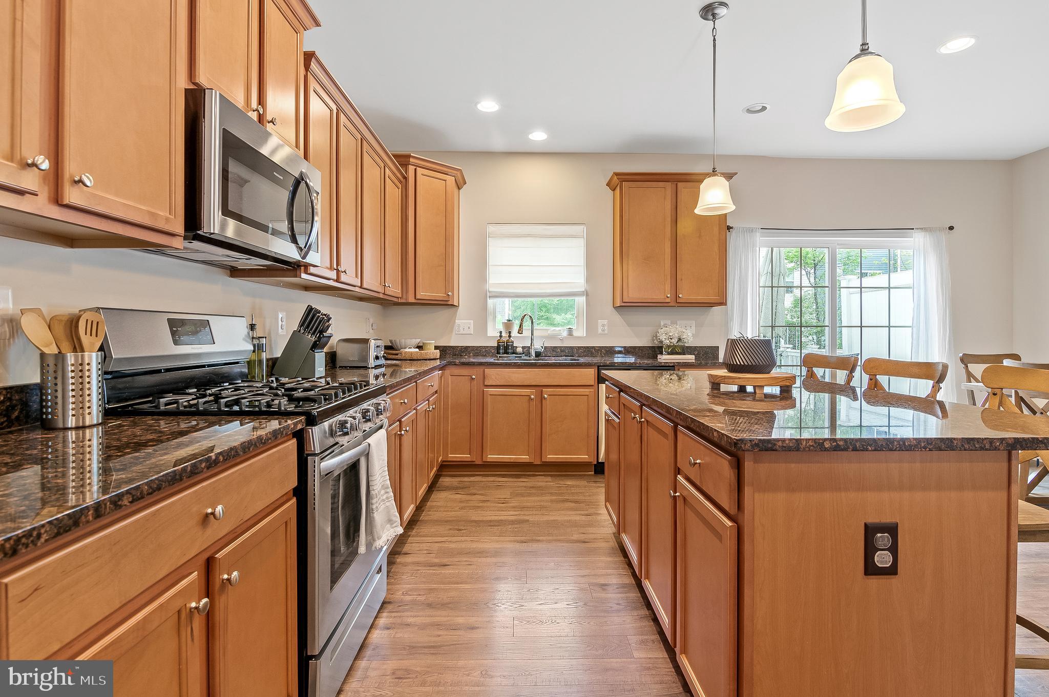 1022 Linden Drive Hanover, MD 21076 - Photo 16 of 42 a kitchen with stainless steel appliances granite countertop a stove a sink dishwasher and a microwave oven with large cabinets