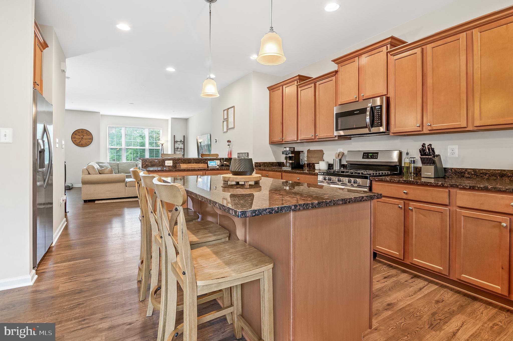 1022 Linden Drive Hanover, MD 21076 - Photo 21 of 42 a kitchen with stainless steel appliances granite countertop a stove top oven a sink dishwasher a dining table and chairs with wooden floor