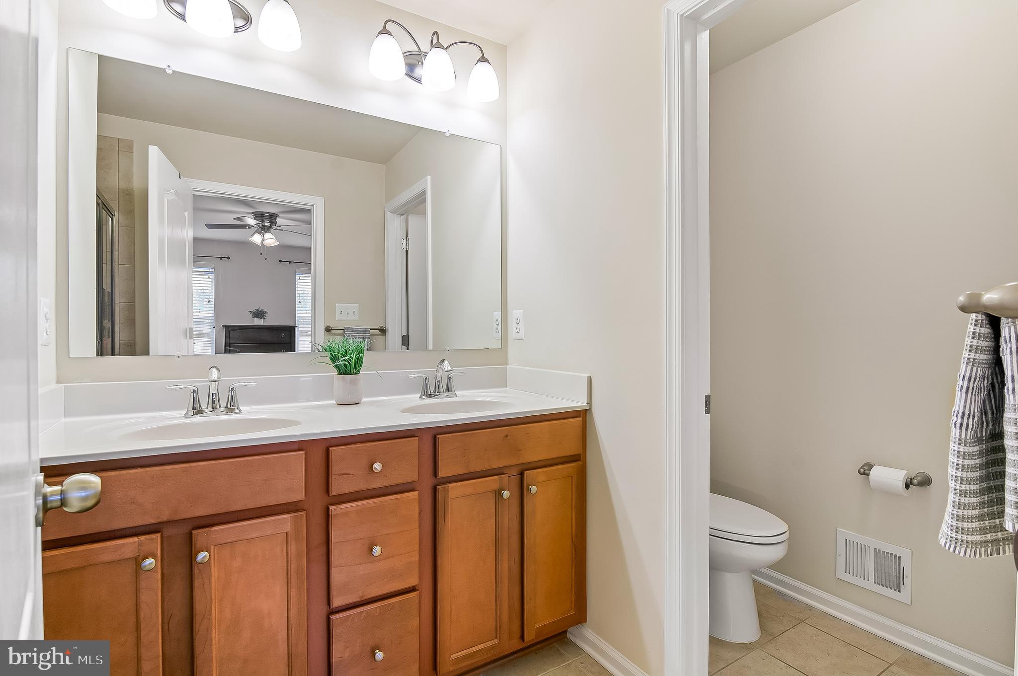 1022 Linden Drive Hanover, MD 21076 - Photo 35 of 42 a bathroom with a double vanity sink toilet and a mirror