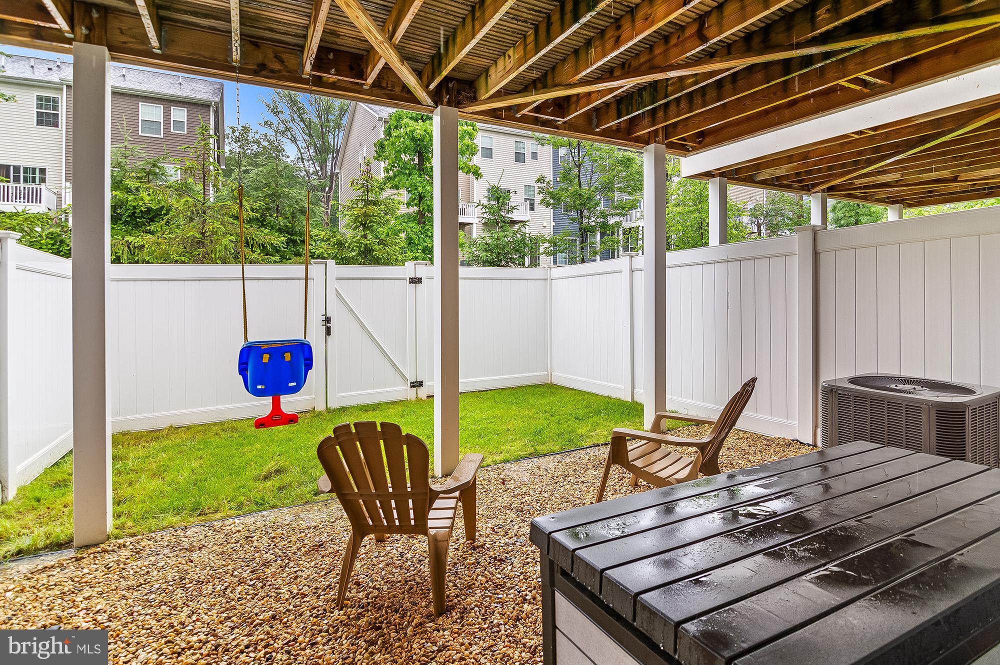 1022 Linden Drive Hanover, MD 21076 - Photo 42 of 42 a view of a backyard with table and chairs potted plants with wooden fence