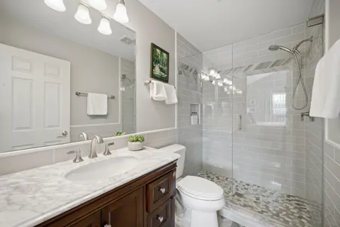 a bathroom with a granite countertop sink toilet and shower