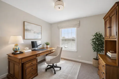 a view of a workspace with furniture and a window