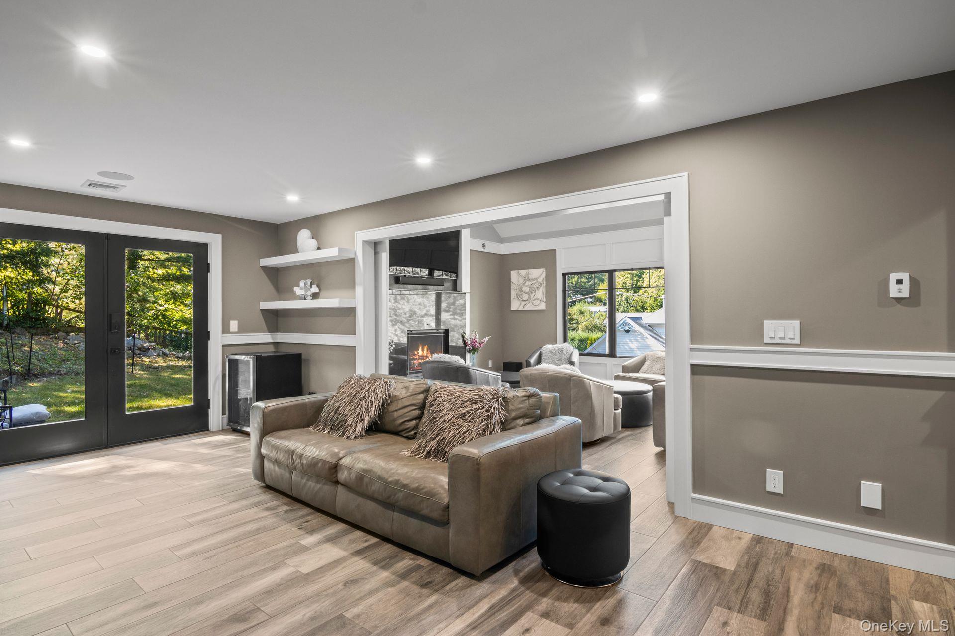 131 Fleets Cove Road Huntington, NY 11743 - Photo 20 of 41 a living room with furniture a flat screen tv and a floor to ceiling window