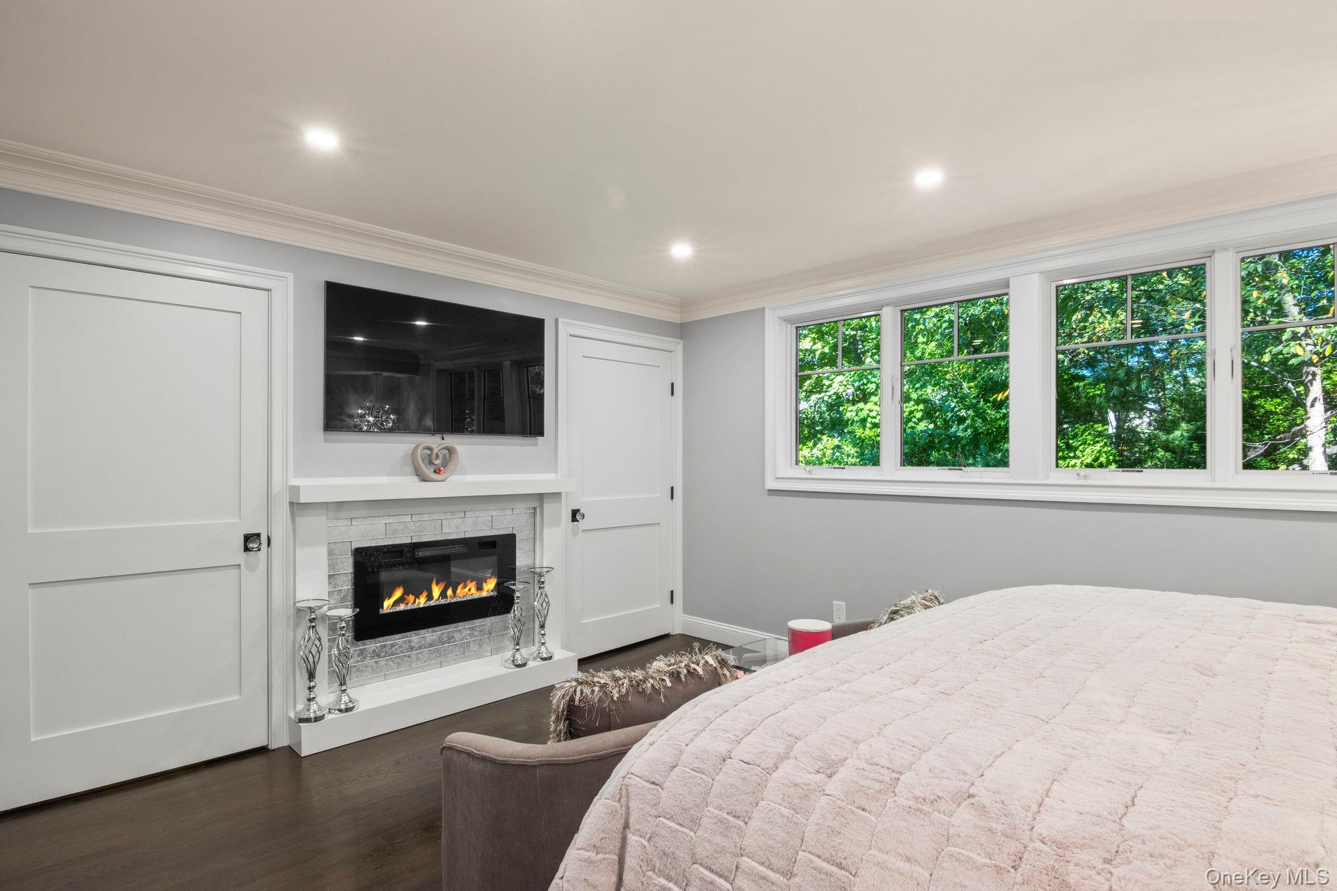 131 Fleets Cove Road Huntington, NY 11743 - Photo 23 of 41 a bedroom with a bed and a fireplace