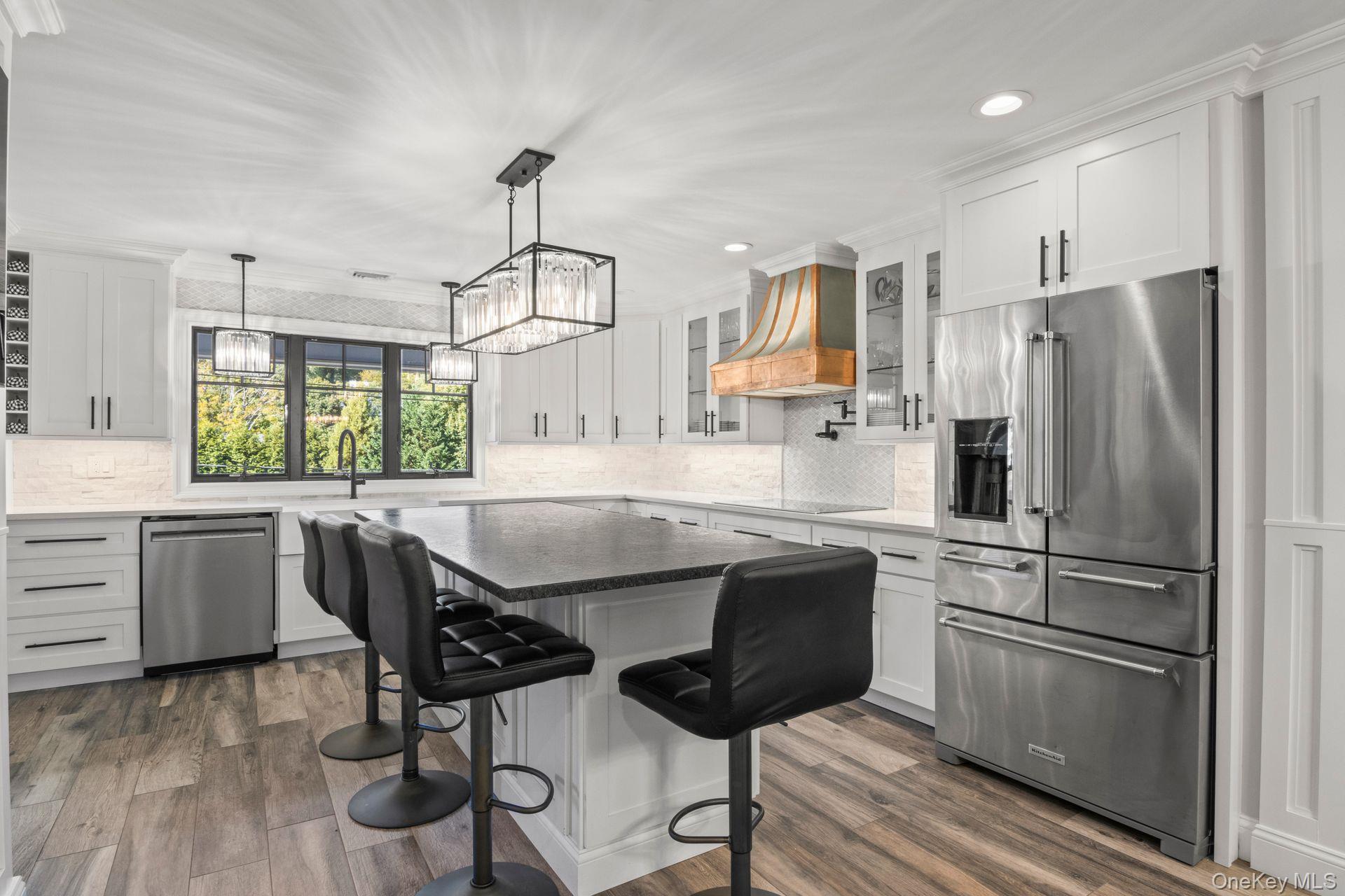 131 Fleets Cove Road Huntington, NY 11743 - Photo 7 of 41 a kitchen with kitchen island white cabinets and stainless steel appliances