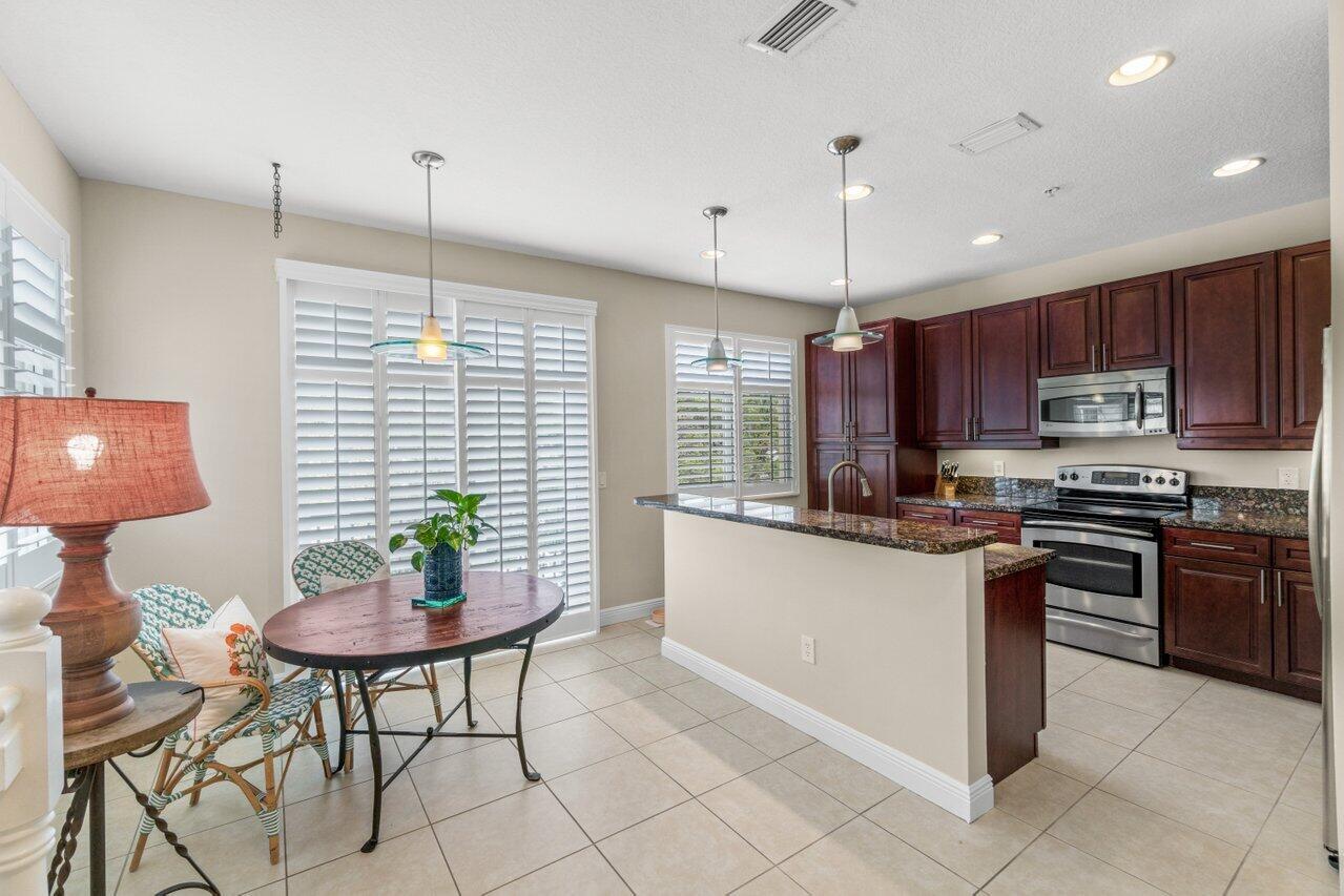 547 Northwest 35th Place Boca Raton, FL 33431 - Photo 9 of 37 a kitchen with stainless steel appliances granite countertop a stove a sink a counter space and cabinets
