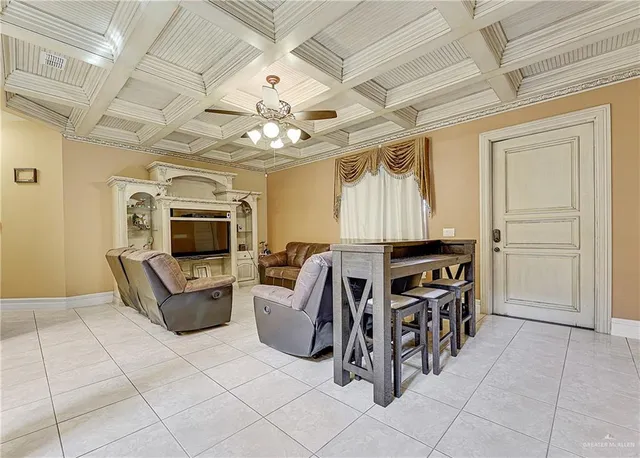 a living room with furniture a flat screen tv and kitchen view