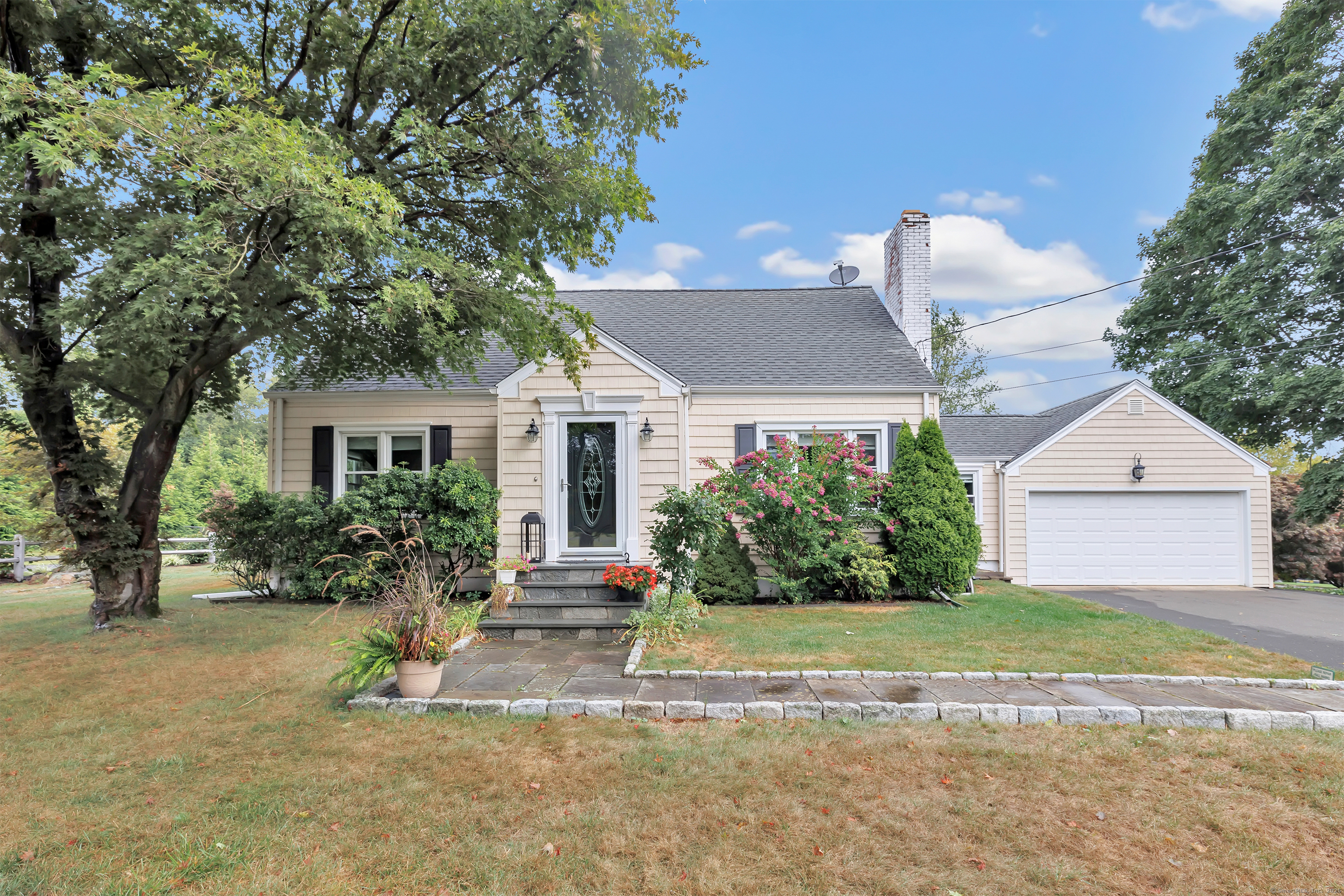 a front view of a house with a yard and potted plants
