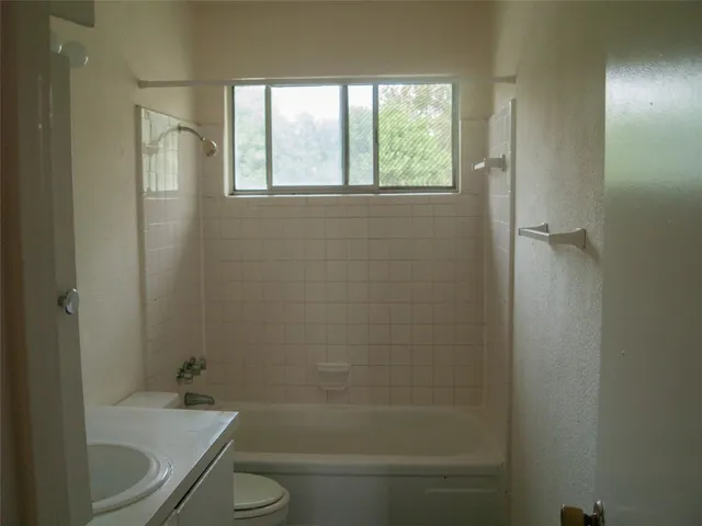 a bathroom with a granite countertop toilet a sink and bathtub