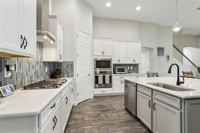 a kitchen with kitchen island stainless steel appliances a sink stove and cabinets