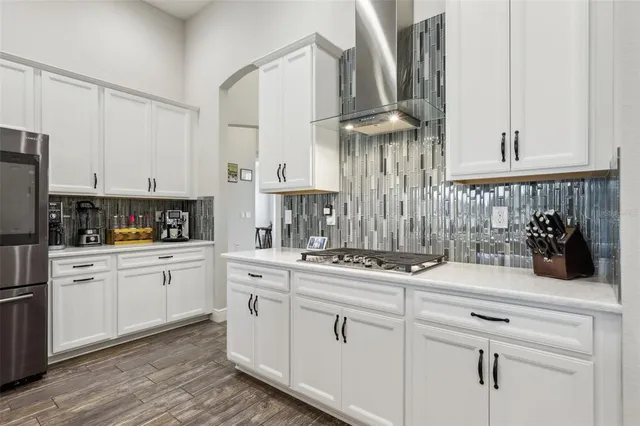 a kitchen with white cabinets and appliances