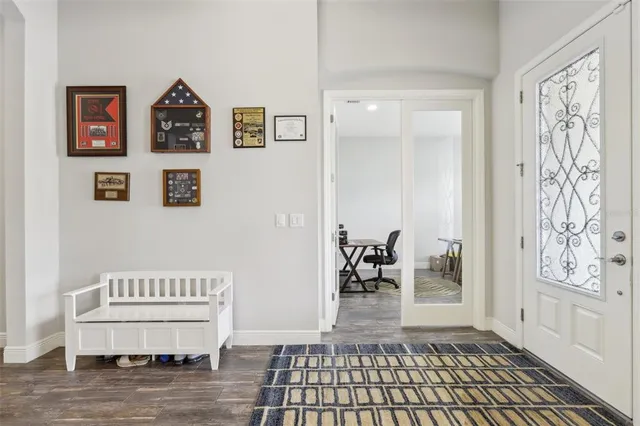 a view of a hallway with wooden floor and furniture