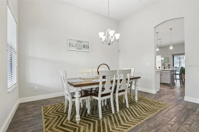 a view of a dining room with furniture a chandelier and wooden floor