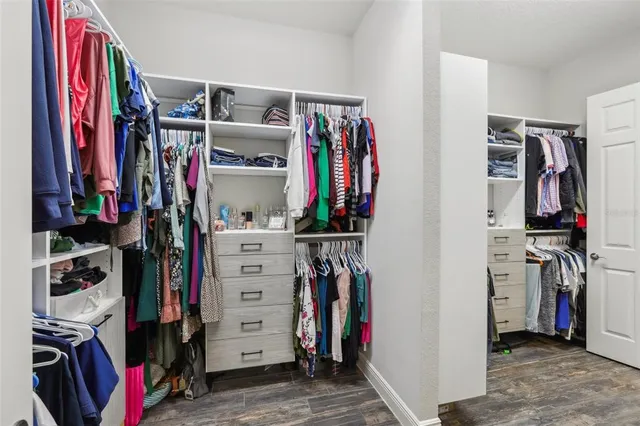 a view of walk in closet with clothes and shoes