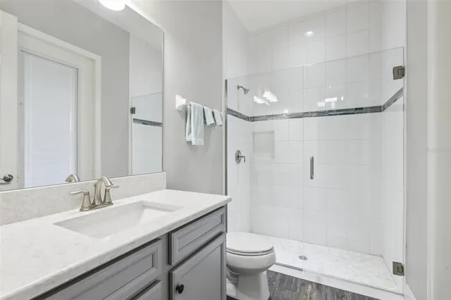 a bathroom with a granite countertop sink toilet and shower