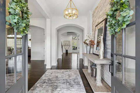 a kitchen with stainless steel appliances granite countertop a sink a stove and a wooden floors