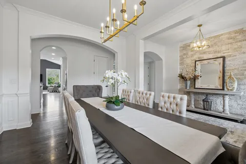 a kitchen with stainless steel appliances granite countertop a stove a sink dishwasher a dining table and chairs with wooden floor