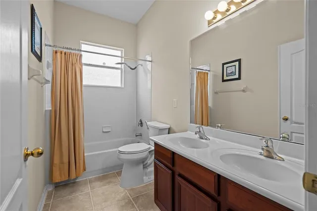 a bathroom with a double vanity sink toilet mirror and shower