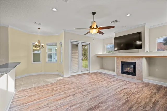 a view of a livingroom with a fireplace a chandelier and wooden floor