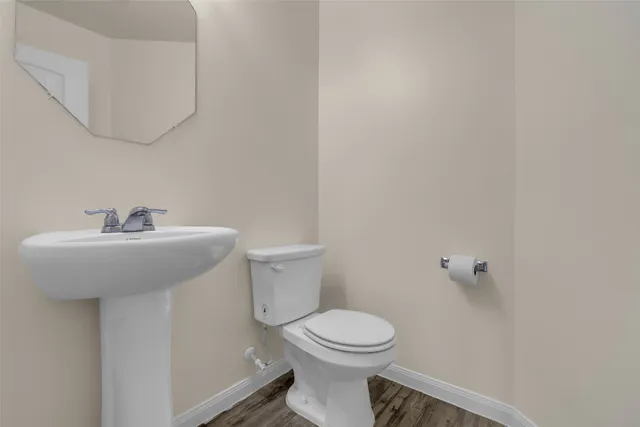 a bathroom with a sink a toilet and mirror