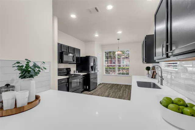 a kitchen with granite countertop a sink stainless steel appliances and counter space