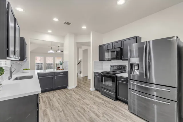 a kitchen with a refrigerator stove and sink