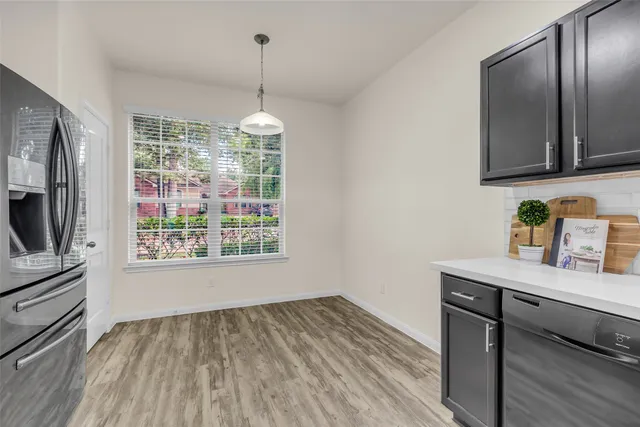 a room with granite countertop wooden floor and stainless steel appliances