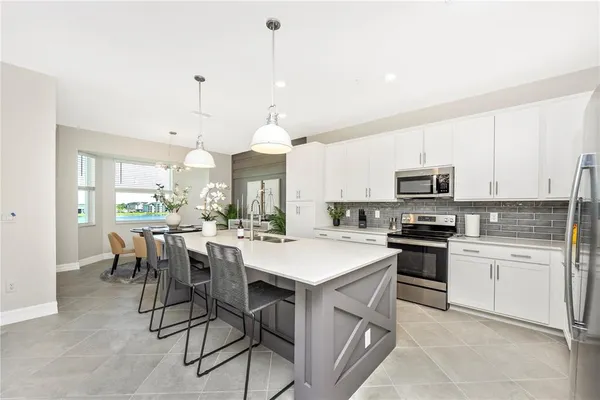 a kitchen with granite countertop a sink stainless steel appliances and white cabinets