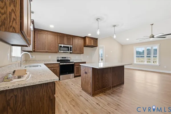 a kitchen with stainless steel appliances kitchen island granite countertop a stove a sink a refrigerator and a microwave