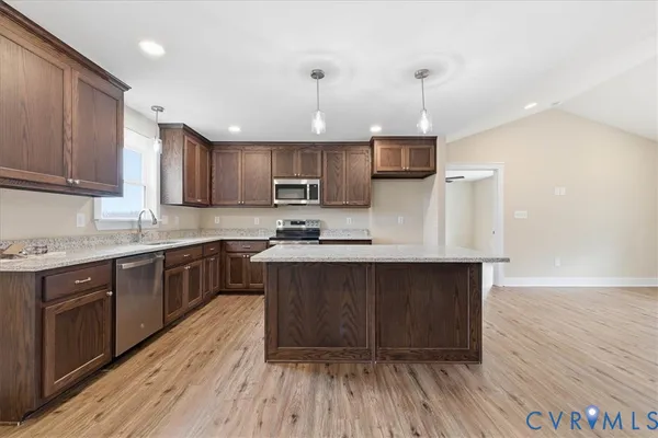 a kitchen with granite countertop wooden floors a sink and cabinets