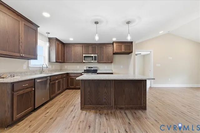 a kitchen with granite countertop wooden floors a sink and cabinets