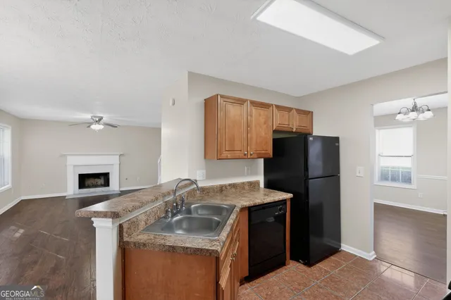 a kitchen with granite countertop a refrigerator stove and sink