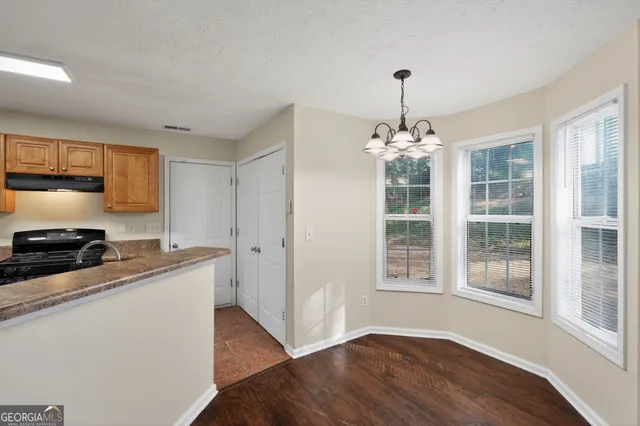 a kitchen that has a lot of windows and wooden cabinets