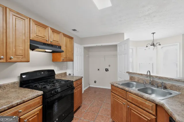 a kitchen with stainless steel appliances granite countertop a sink stove and cabinets