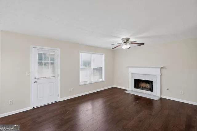a view of a livingroom with a fireplace wooden floor and windows