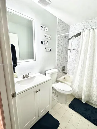 a bathroom with a sink a toilet a mirror a vanity and shower