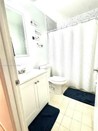 a bathroom with a sink a toilet a window and a mirror
