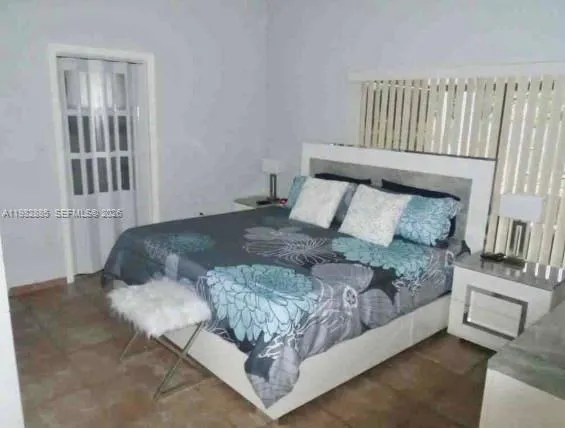a bed sitting in a bedroom next to a window with walls
