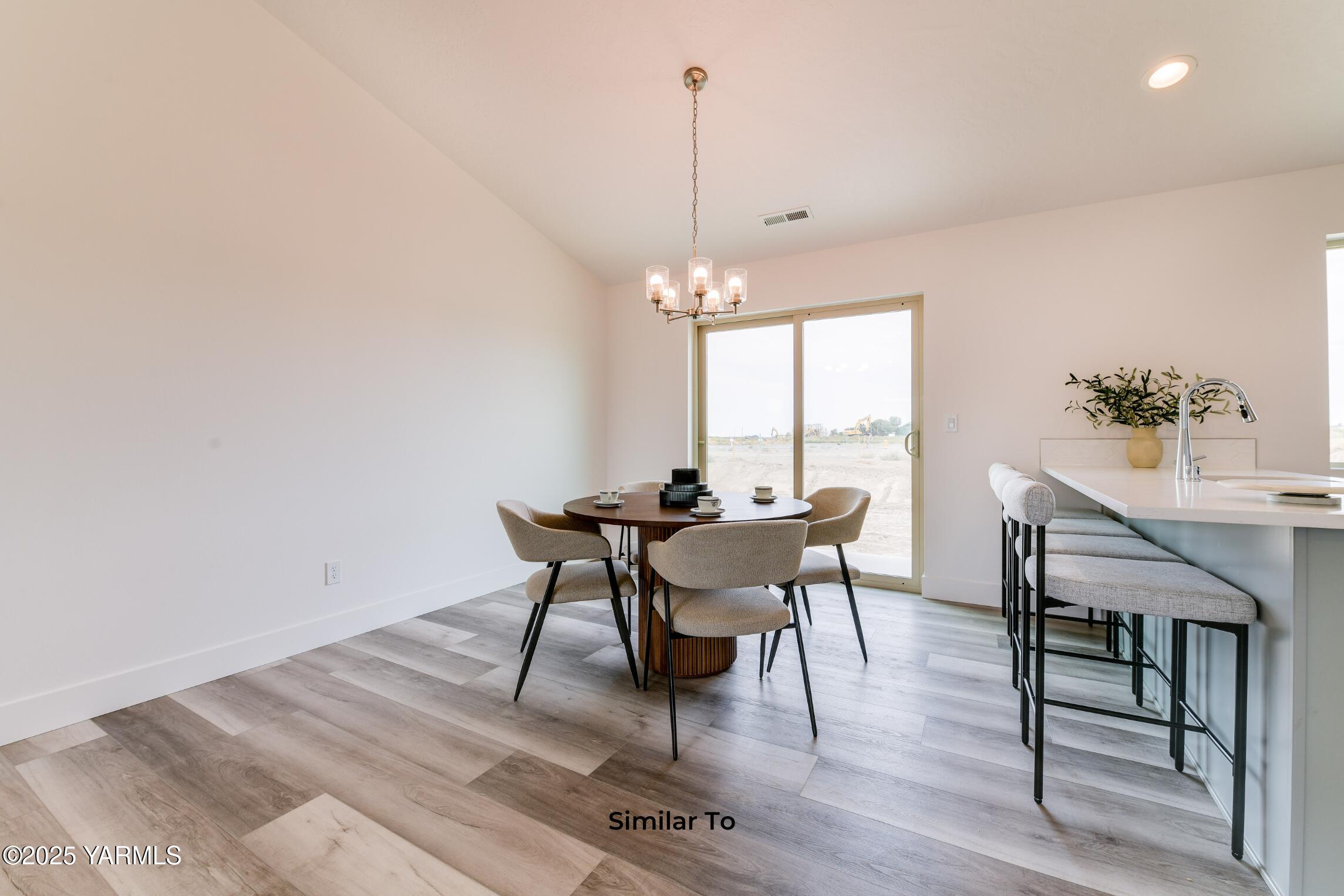 604 Vineyard Street, Unit PHASE 2 LOT 13) SPEC Grandview, WA 98930 - Photo 5 of 19 a dining room with furniture a rug and a chandelier