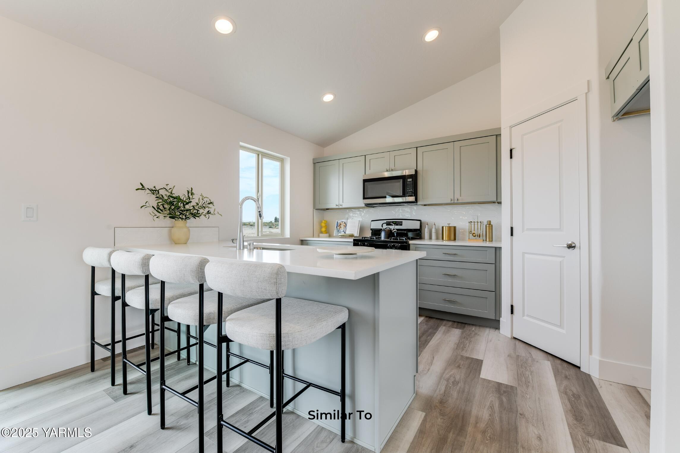 604 Vineyard Street, Unit PHASE 2 LOT 13) SPEC Grandview, WA 98930 - Photo 6 of 19 a kitchen with kitchen island granite countertop wooden floor and stainless steel appliances
