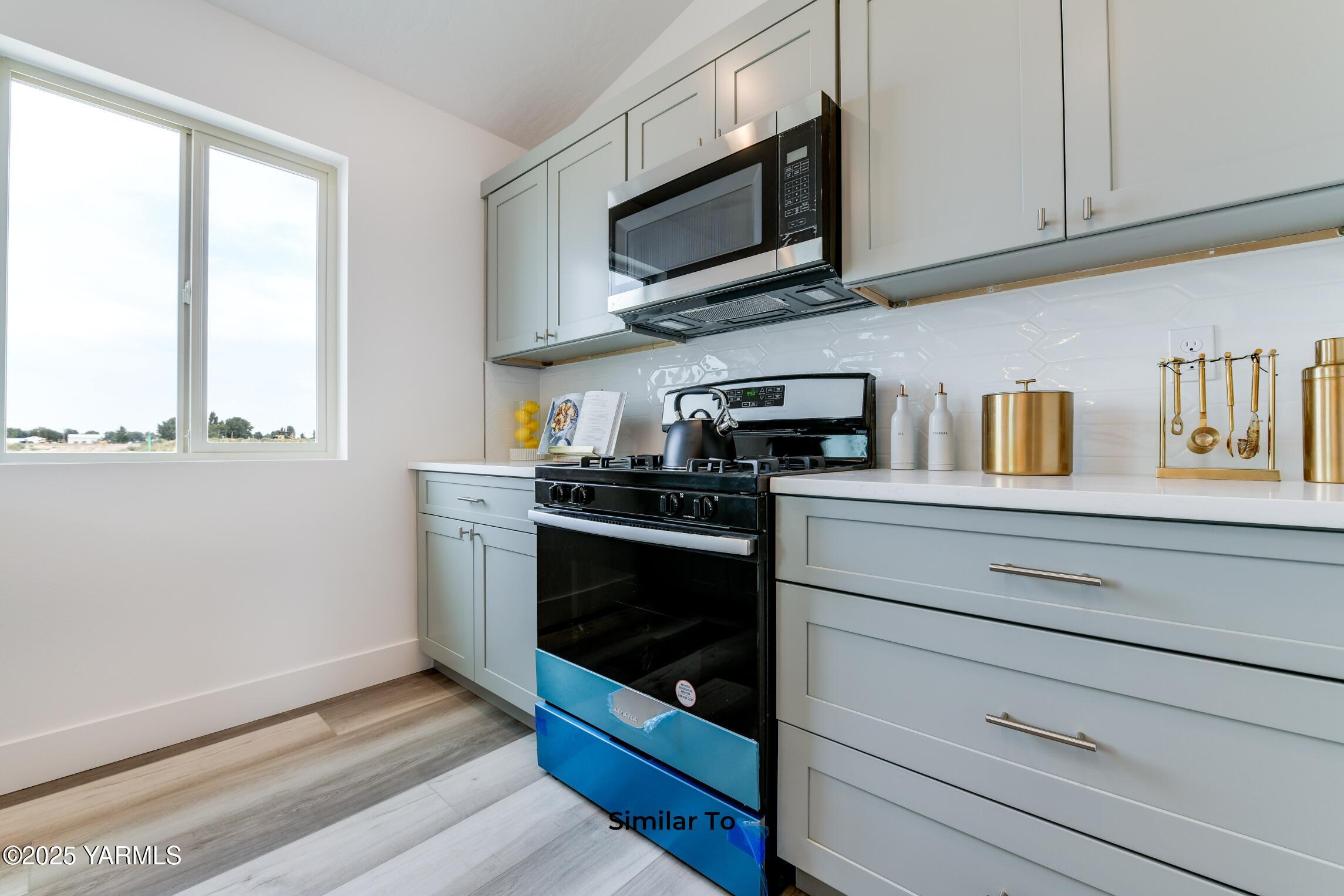 604 Vineyard Street, Unit PHASE 2 LOT 13) SPEC Grandview, WA 98930 - Photo 7 of 19 a kitchen with stainless steel appliances granite countertop white cabinets a window and a sink