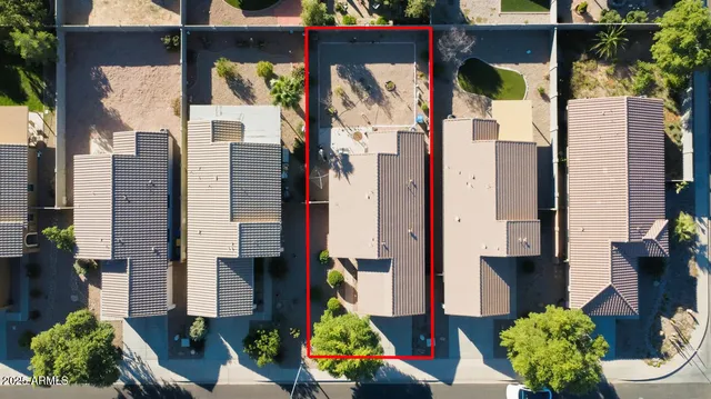 an aerial view of ocean and residential houses with outdoor space