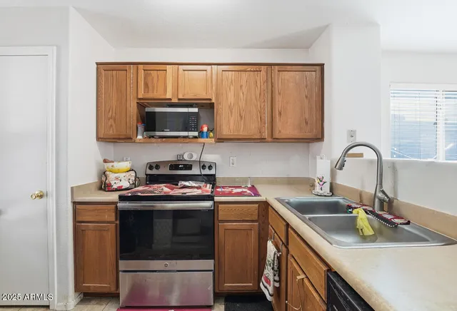 a kitchen with stainless steel appliances granite countertop a stove a sink and a microwave