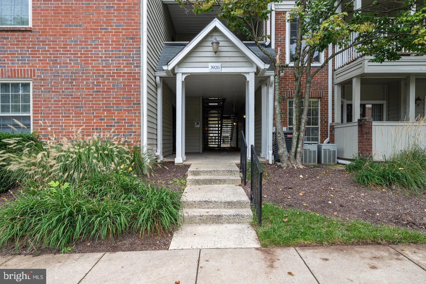 a front view of a house with a yard and potted plants