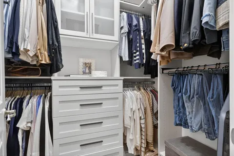 a view of walk in closet with clothes and shoes
