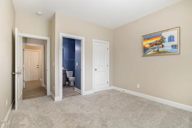 an empty room with closet and a bathroom