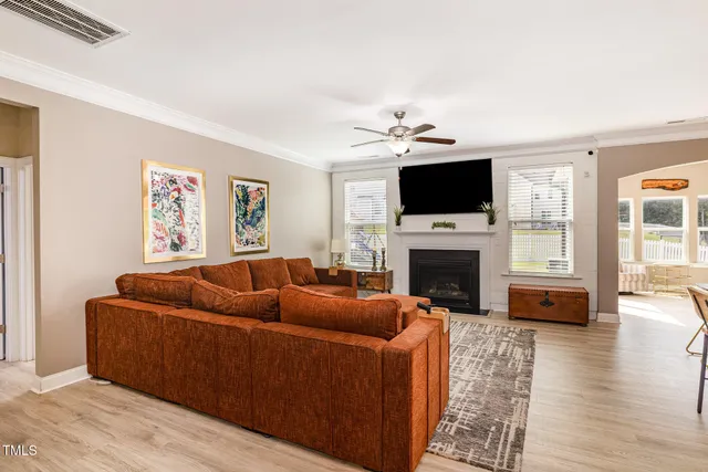 a living room with furniture a flat screen tv and a fireplace